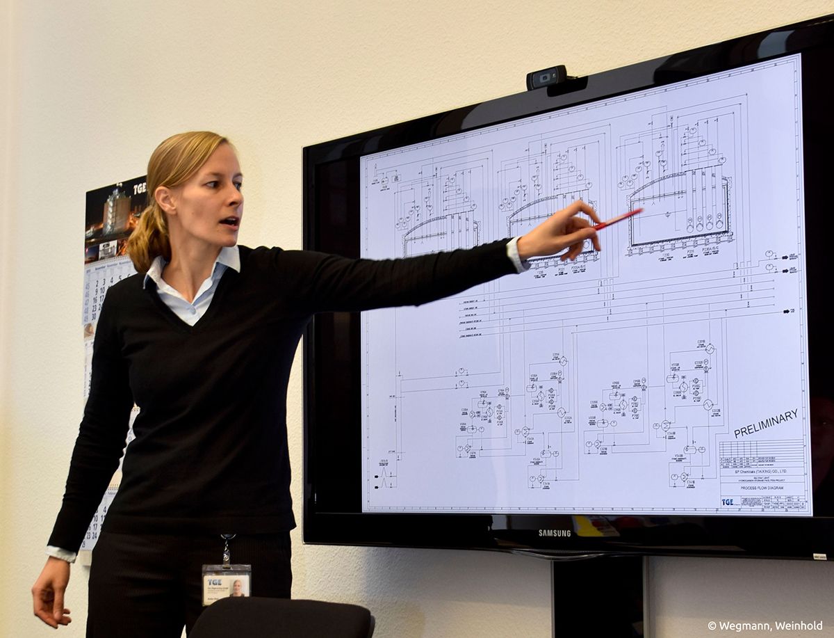 Anke Patt, Prozessingenieurin bei TGE Gas Engineering in Bonn, erklärt den Plan einer Chemieanlage. /Bildquelle: Wegmann, Weinhold
