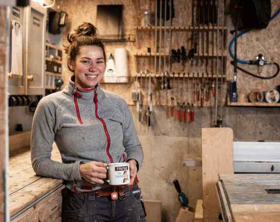 Schreinerin Betty Kappeller mit einer Kaffeetasse in ihrer Werkstatt