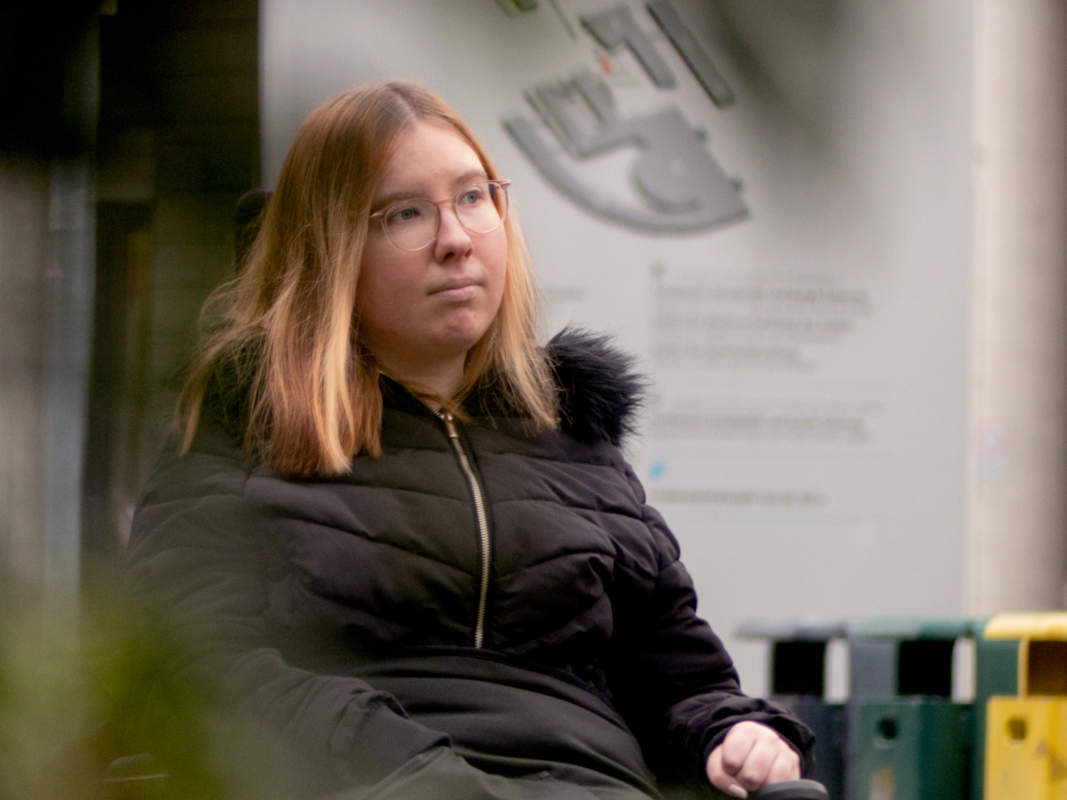 Karolin Odenthal im Rollstuhl vor der Hochschule
