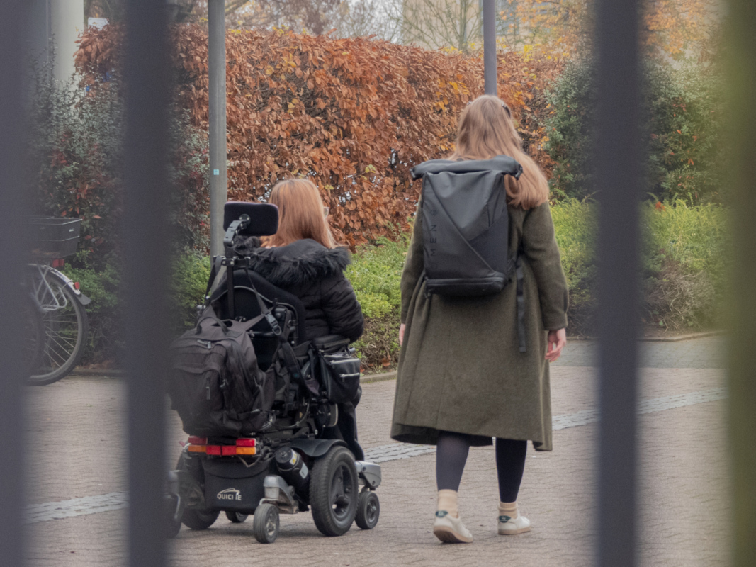 Karolin Odenthal und eine Begleitung von hinten auf dem Hochschulgelände