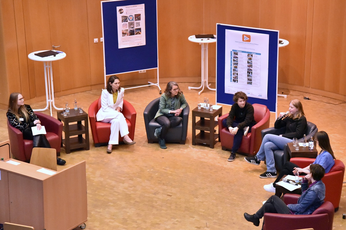 Die Teilnehmerinnen der Diskussionsrunde sitzen im Halbkreis auf ihren Sesseln, während Annika zu den Leitlinien spricht
